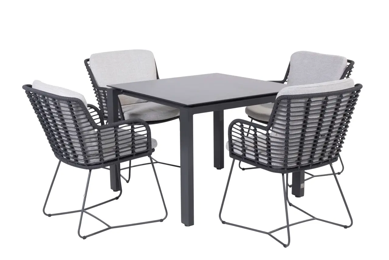 Goa Dining Tisch 95x95cm, quadratischer schwarzer Tisch mit vier schwarzen geflochtenen Stühlen und hellgrauen Kissen.