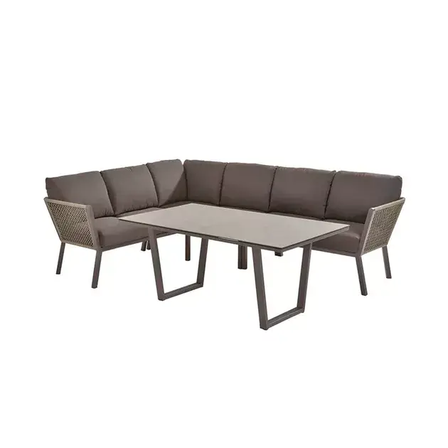 Cocoon Cozy Dining Sitzgruppe: Braunes gepolstertes L-förmiges Outdoor-Sofa mit rechteckigem Tisch mit grauer Platte und Metallbeinen.