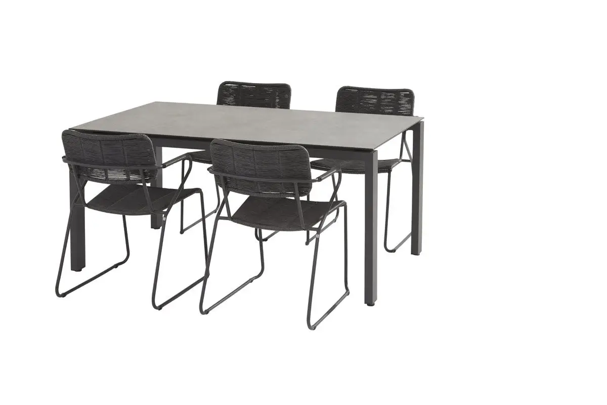 Der Goa Dining Tisch, ein rechteckiger Tisch mit grauer Platte, wird mit vier schwarzen Metallstühlen mit geflochtener Rückenlehne geliefert.