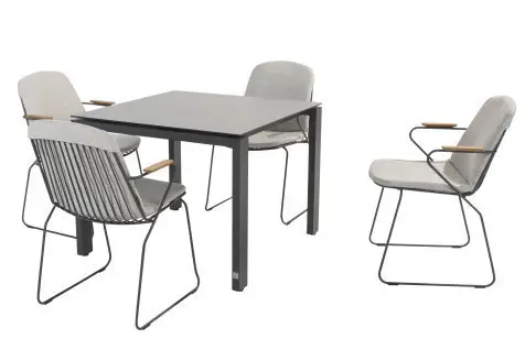 Vier moderne graue Stühle mit gepolsterten Sitzen umgeben einen Goa Dining Tisch 95x95cm auf einem weißen Hintergrund.