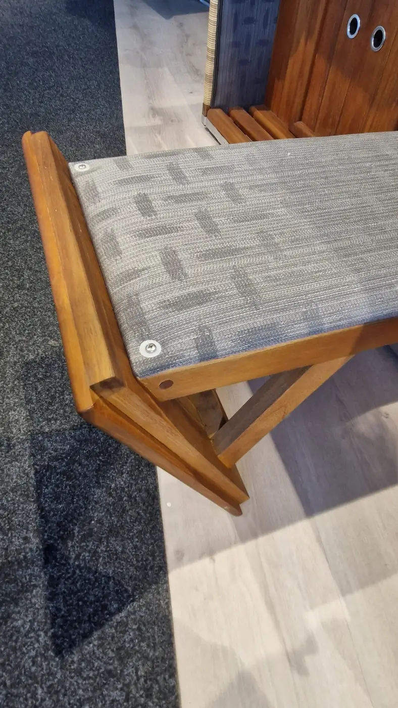 Ein Strandkorb Präsident Teak - Musterabverkauf Bank mit einem grauen gepolsterten Sitz auf Teppich und Holzboden. Gartenmöbel und Grills kaufen in Rostock, Mecklenburg-Vorpommern.