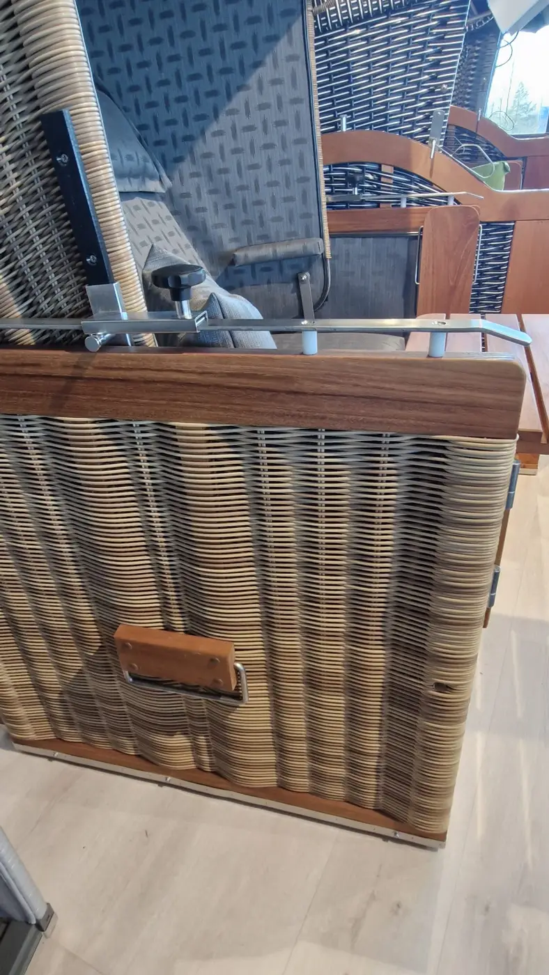 Nahaufnahme des Strandkorbs Präsident Teak - Musterabverkauf mit gewellten Lamellen und einem rechteckigen Griff am Boden. Gartenmöbel und Grills kaufen in Rostock, Mecklenburg-Vorpommern.