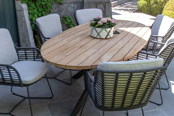 Ovaler Terrassentisch aus Holz mit sechs gepolsterten Stühlen, ideal für Gartenmöbel oder zum Aufstellen Ihres Grillzubehörs. Gartenmöbel und Grills kaufen in Rostock, Mecklenburg-Vorpommern.